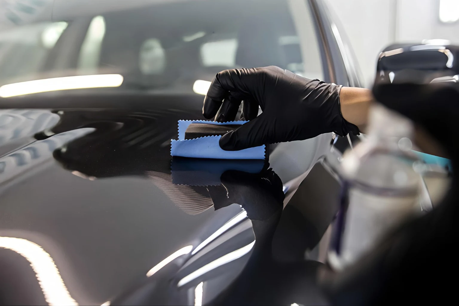 Technician applying ceramic coating to a vehicle panel at WG Detailing